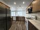 Modern kitchen with stainless steel appliances, wood cabinets, light countertops, and wood flooring at 6638 Babys Tear Pl, Las Vegas, NV 89148