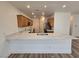 Well-lit kitchen featuring long breakfast bar with sink, wood cabinets, and stainless appliances at 6638 Babys Tear Pl, Las Vegas, NV 89148