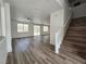 Open concept living room with wood floors, natural light, and staircase access at 6638 Babys Tear Pl, Las Vegas, NV 89148