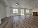 Open-concept living room with wood-look floors, ample natural light, and easy access to the backyard patio at 6638 Babys Tear Pl, Las Vegas, NV 89148