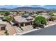 Aerial view of the home showing a three-car garage, brick paved driveway, and solar panels at 7300 Fresh Harvest Ave, Las Vegas, NV 89131