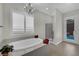 Bathroom featuring a soaking tub, tiled floor, glass shower, and access to the backyard pool area at 7300 Fresh Harvest Ave, Las Vegas, NV 89131
