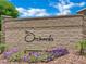 Stone community entrance with flower beds, a bench, and 