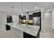 Modern kitchen with stainless appliances, an island with bar seating, pendant lighting, and a stylish backsplash at 7300 Fresh Harvest Ave, Las Vegas, NV 89131