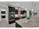 Well-equipped kitchen featuring an island, stainless appliances, a tile backsplash, and dark wood cabinetry at 7300 Fresh Harvest Ave, Las Vegas, NV 89131