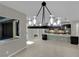 The kitchen area opens to a spacious tiled living area with recessed lighting, an island, and black pendant lights at 7300 Fresh Harvest Ave, Las Vegas, NV 89131