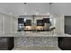An open kitchen with a large island, stainless appliances, dark cabinets, and stylish pendant lighting at 7300 Fresh Harvest Ave, Las Vegas, NV 89131
