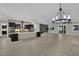 Spacious living area with modern chandelier and view into the kitchen and backyard at 7300 Fresh Harvest Ave, Las Vegas, NV 89131