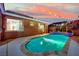 A sparkling pool with a tanning ledge is surrounded by concrete and a privacy wall at 7300 Fresh Harvest Ave, Las Vegas, NV 89131
