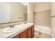 Bright bathroom featuring double vanity, neutral tiling, and bathtub with shower at 7332 Redhead Dr, North Las Vegas, NV 89084