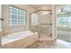 Bright bathroom featuring a bathtub, glass encased shower, and modern fixtures at 7332 Redhead Dr, North Las Vegas, NV 89084