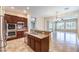 Open-concept kitchen boasting stainless steel appliances, dark wood cabinets, and granite countertops with an adjacent dining area at 7332 Redhead Dr, North Las Vegas, NV 89084