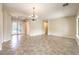 Bright living room featuring tile flooring, neutral walls, decorative chandelier, and an entryway with glass doors at 7332 Redhead Dr, North Las Vegas, NV 89084