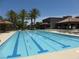 Large swimming pool with lane markers, surrounded by lounge chairs and palm trees at 7332 Redhead Dr, North Las Vegas, NV 89084