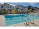Community pool surrounded by desert landscaping and modern townhomes featuring clear blue water at 7505 Emerald Stars St # 101, North Las Vegas, NV 89084