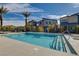 A community pool with clear blue water, surrounded by modern townhomes and desert landscaping under a sunny sky at 7505 Emerald Stars St # 101, North Las Vegas, NV 89084