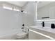 Modern bathroom with shower-tub combo, toilet, and vanity with a lighted mirror at 7865 March Brown Ave, Las Vegas, NV 89149