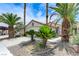 Single-story home featuring desert landscaping, lush palm trees and a white two-car garage at 7865 March Brown Ave, Las Vegas, NV 89149