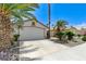 Single-story home showcasing desert landscaping, healthy palm trees and a white two-car garage at 7865 March Brown Ave, Las Vegas, NV 89149