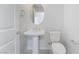 Modern powder room features a pedestal sink, oval mirror, and a standard toilet at 789 Black Palace St, Henderson, NV 89011