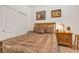 Cozy bedroom featuring warm tones, comfortable bedding, and two decorative wall pictures at 789 Drammatico Pl, Henderson, NV 89011