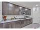 Well-lit kitchen featuring updated stainless steel appliances, granite countertops, and dark wood cabinets at 789 Drammatico Pl, Henderson, NV 89011