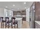 Bright kitchen with stainless appliances, white countertops, dark wood cabinets, and barstool seating at 789 Drammatico Pl, Henderson, NV 89011