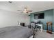 Comfortable bedroom with ceiling fan and modern teal accent wall over desk at 8261 Selenite St, Las Vegas, NV 89113