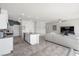 Open-concept living area with island, white cabinets, stainless appliances, and a cozy sofa, perfect for entertaining at 8261 Selenite St, Las Vegas, NV 89113