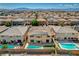 An elevated shot of a neighborhood highlighting residences with pools, landscaping, and rooftop solar panels at 8448 Cambria Cellars Ct, Las Vegas, NV 89139