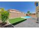 Backyard featuring a small pool, artificial turf, and a block wall at 8448 Cambria Cellars Ct, Las Vegas, NV 89139