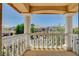 Balcony view through decorative columns showcasing the neighborhood homes and lush greenery at 8448 Cambria Cellars Ct, Las Vegas, NV 89139