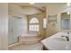 Bright bathroom with dual sinks, soaking tub, and glass shower at 8448 Cambria Cellars Ct, Las Vegas, NV 89139