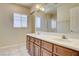 Bright bathroom featuring a double sink vanity with white countertops, tile floors, and a framed mirror at 8448 Cambria Cellars Ct, Las Vegas, NV 89139