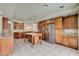 Large kitchen with granite counters, island, tile floors, and stainless steel refrigerator at 8448 Cambria Cellars Ct, Las Vegas, NV 89139