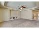 Spacious living room with carpet, ceiling fan, and built-in shelving for storage and media at 8448 Cambria Cellars Ct, Las Vegas, NV 89139