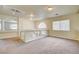 Carpeted loft with arched window, glass railing, and neutral walls, creates a cozy and inviting upper-level living area at 8448 Cambria Cellars Ct, Las Vegas, NV 89139