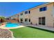 A private backyard featuring a sparkling pool, lush artificial grass, and well-maintained landscaping at 8448 Cambria Cellars Ct, Las Vegas, NV 89139