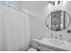 Bright white bathroom featuring a decorative mirror, white shower curtain, and modern toilet at 8705 Fordster St, Las Vegas, NV 89166