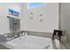 Bright bathroom highlighting a soaking tub with elegant decor for a relaxing retreat at 8705 Fordster St, Las Vegas, NV 89166