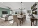 Bright dining area with natural light, a long table, and a view to the adjacent living room at 8705 Fordster St, Las Vegas, NV 89166