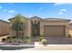 Inviting front exterior features a stylish stucco facade, desert landscaping, and attached two car garage at 8705 Fordster St, Las Vegas, NV 89166