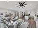 Open-concept living room featuring a large sectional sofa and view to the kitchen with white cabinets at 8705 Fordster St, Las Vegas, NV 89166