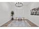 Modern office with glass desk, comfortable chair, chandelier lighting, and stylish airplane artwork at 8705 Fordster St, Las Vegas, NV 89166