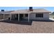 View of backyard with rock ground cover, covered patio, and solar panels at 878 Samoy St, Las Vegas, NV 89110