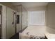Bathroom featuring a large soaking tub, walk-in shower, and a large window at 878 Samoy St, Las Vegas, NV 89110