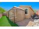 A fully furnished gazebo sits on a paver patio next to a artificial lawn, creating an inviting outdoor experience at 9104 Ashiwi Ave, Las Vegas, NV 89178
