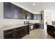 Modern kitchen featuring stainless steel appliances, granite countertops, dark cabinetry, and tile backsplash at 9104 Ashiwi Ave, Las Vegas, NV 89178