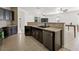 Modern kitchen featuring stainless steel appliances, granite countertops, breakfast bar, and seamless flow to living area at 9104 Ashiwi Ave, Las Vegas, NV 89178