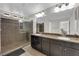 Bathroom with dual sinks, granite counters, and a spacious glass shower with a tile surround at 9604 Stoney Mesa Ct, Las Vegas, NV 89139